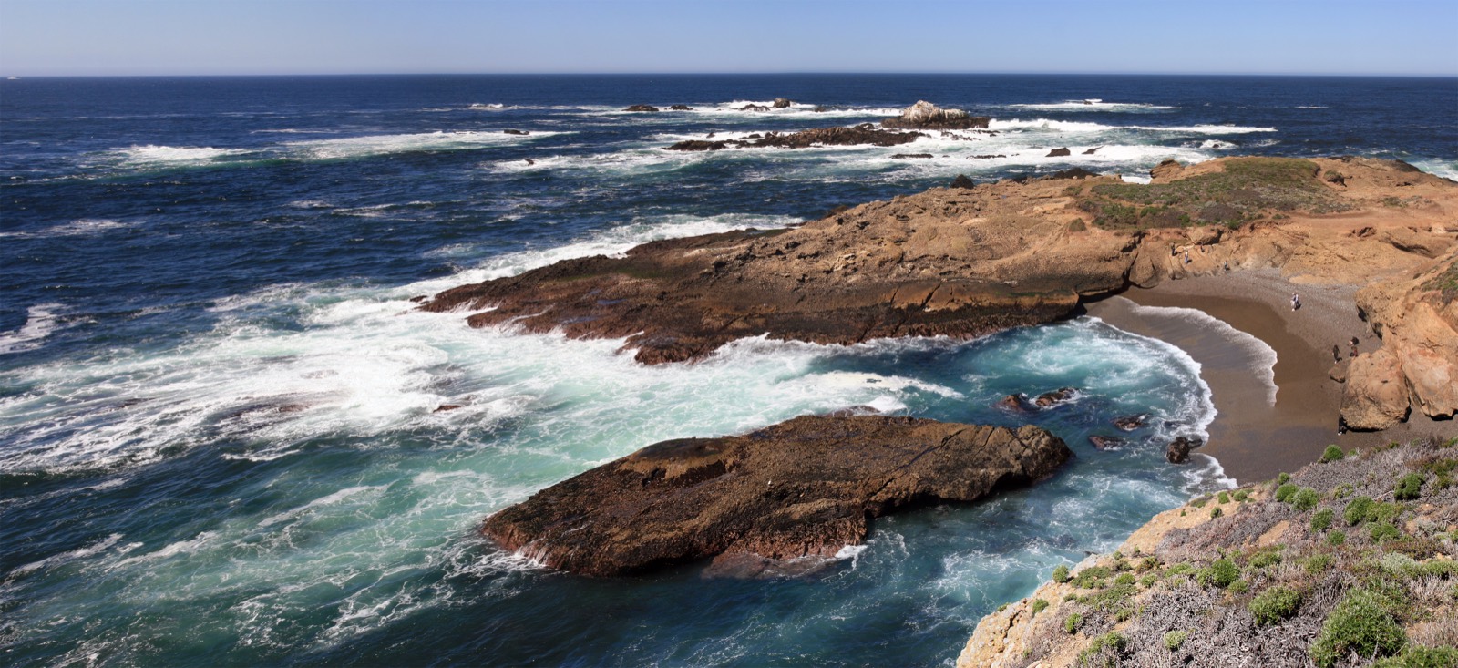 Point Lobos coastal headlands with cypress trees, cliffs, and bright blue Pacific water.